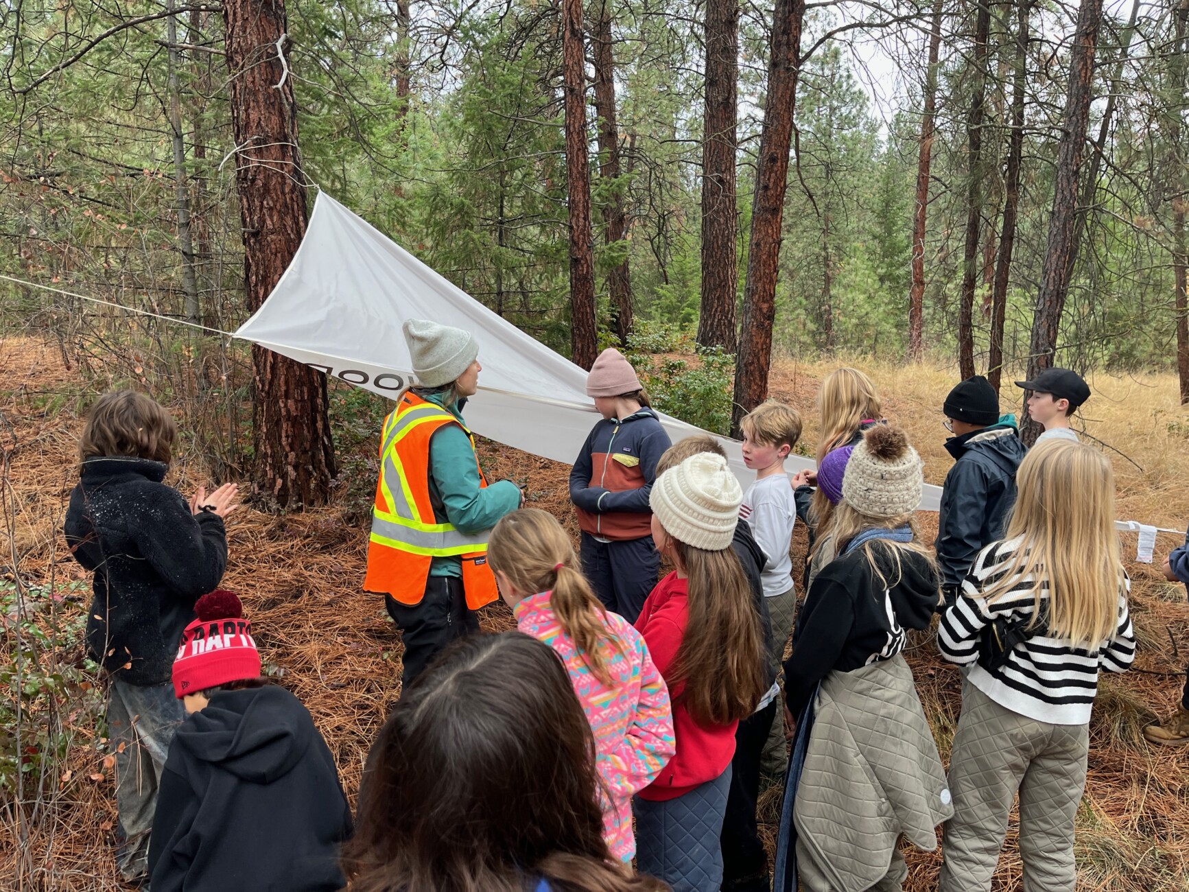 students around tent and teacher